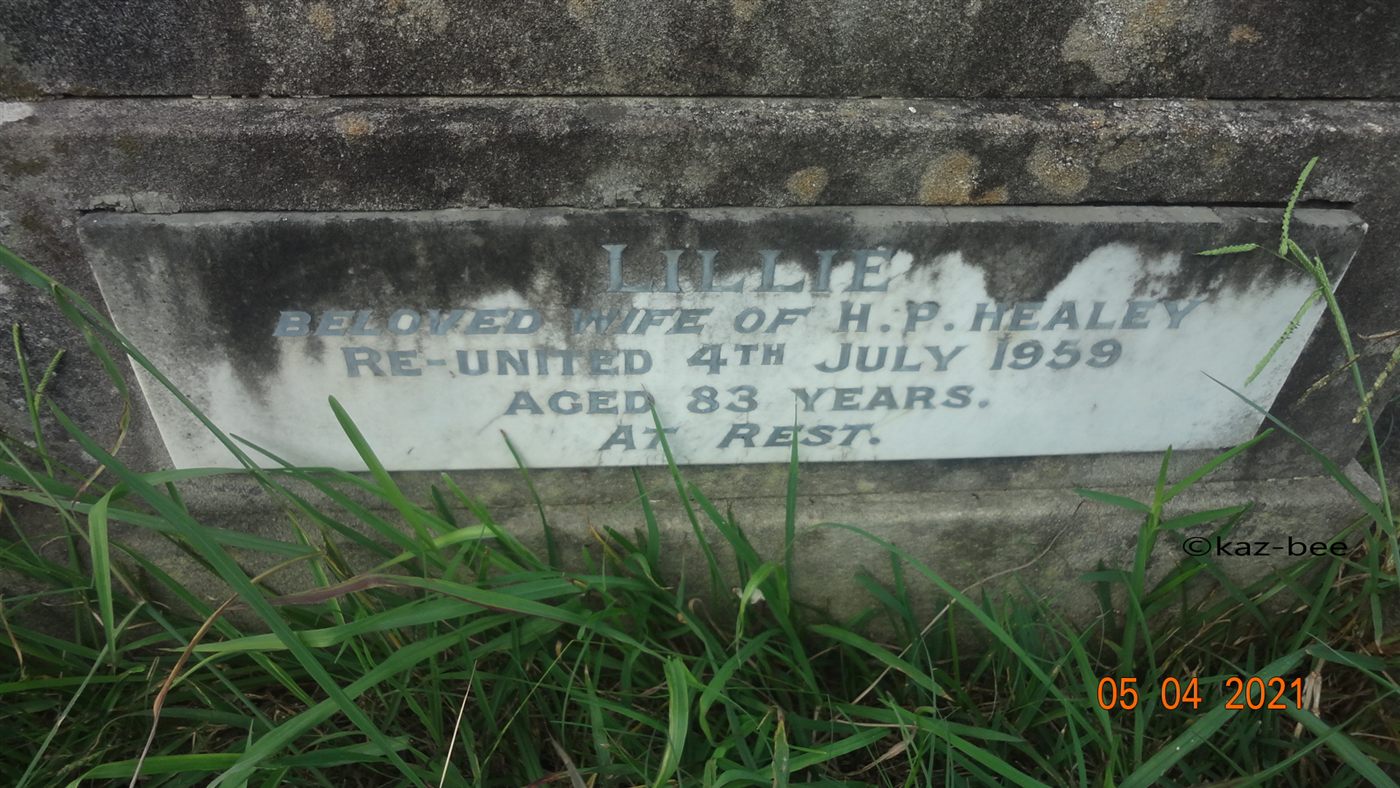A marble headstone panel inscribed “Lillie, beloved wife of H.P. Healey, re-united 4th July 1959, aged 83 years, at rest.”