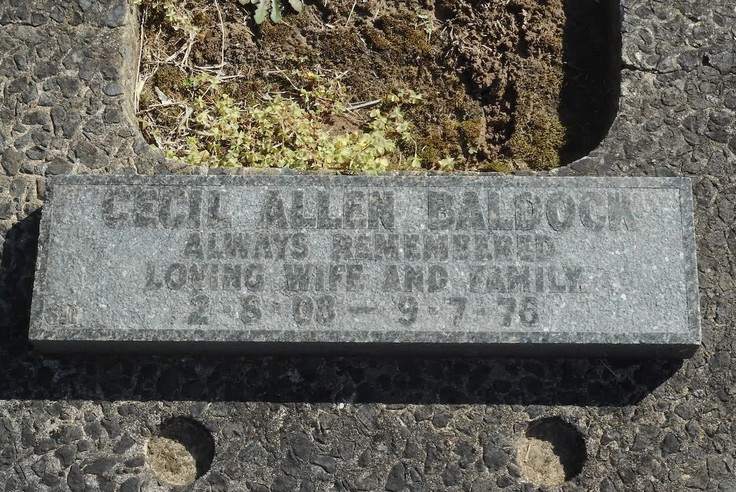 A granite plaque reading "Cecil Allen Baldock, always remembered, loving wife and family, 2.8.08 - 9.7.76."