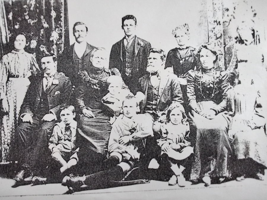 Studio group portrait of the Robens family — Thomas and Mary Rebecca Jane seated at the centre, surrounded by their twelve children, the youngest held as a baby in her mother’s arms.