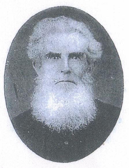 Oval studio portrait of an elderly man with a full white beard and swept-back white hair, wearing a dark coat, looking slightly away from the camera.