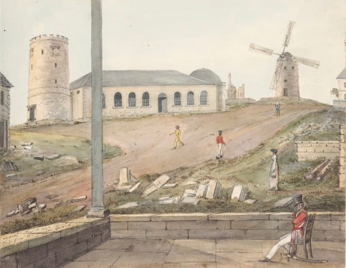 A watercolour view of early colonial Sydney, c.1817, showing a windmill on a hill, a plain colonial church building with arched windows, and gravestones scattered on the hillside in the foreground, with a soldier in a red coat seated in the foreground.